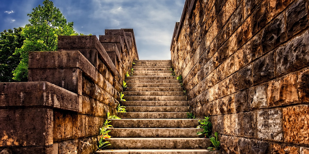 Old stone steps lined with green lead up to the sky