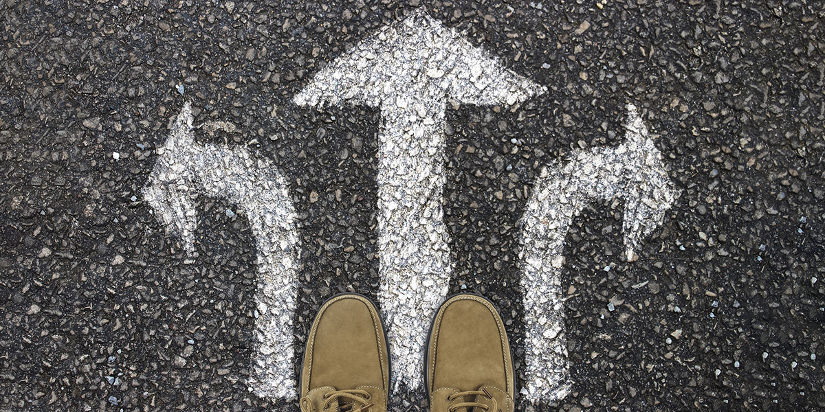 feet stand in front of a 3 arrows painted on the ground