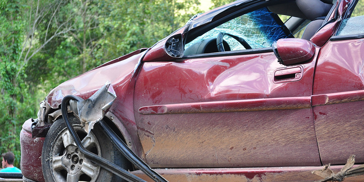 a red sedan that is smashed from a recent car accident