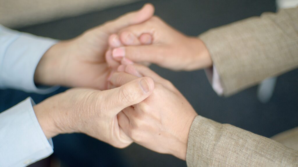 A close-up of hands holding each other