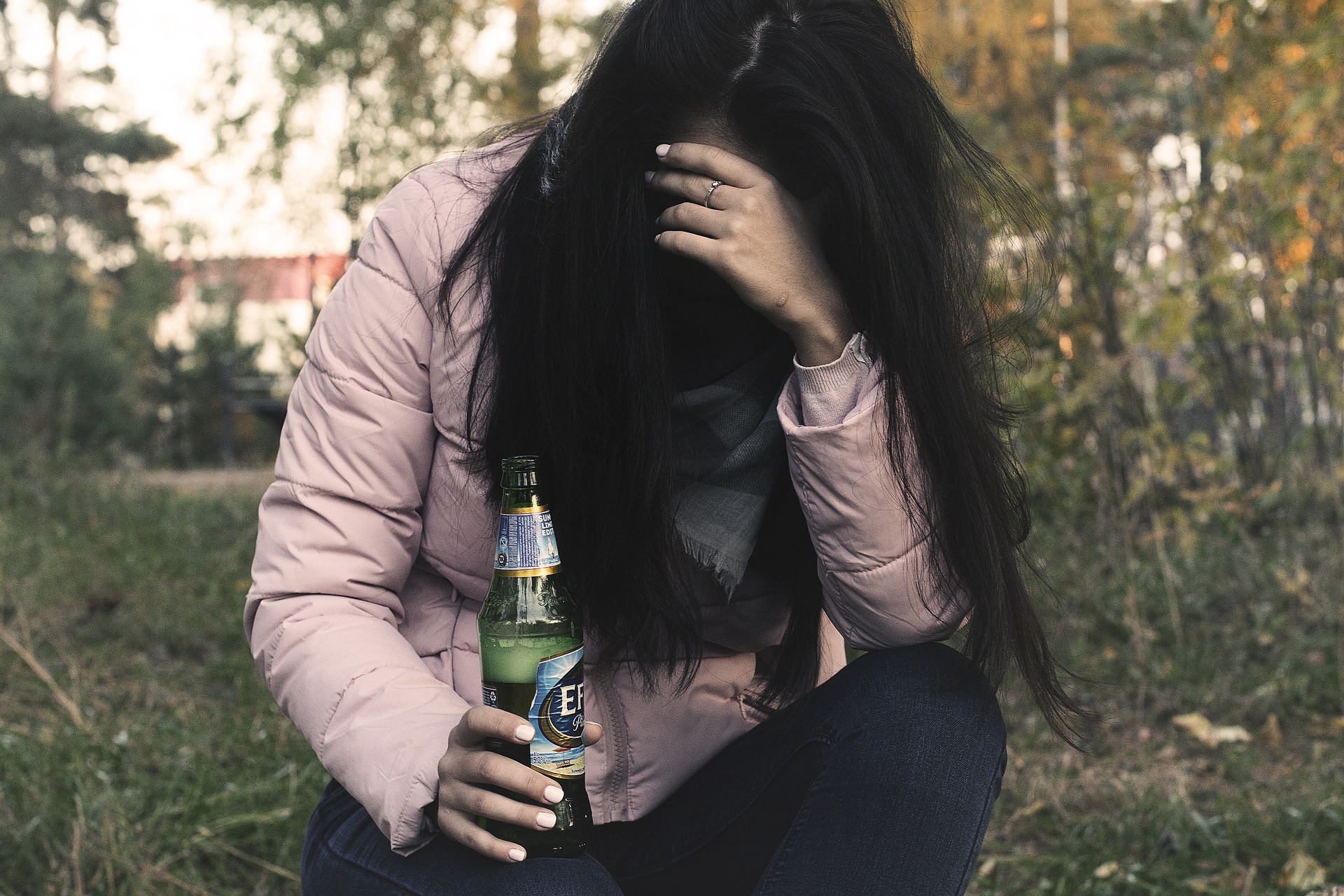 Female alcoholic holding a bottle