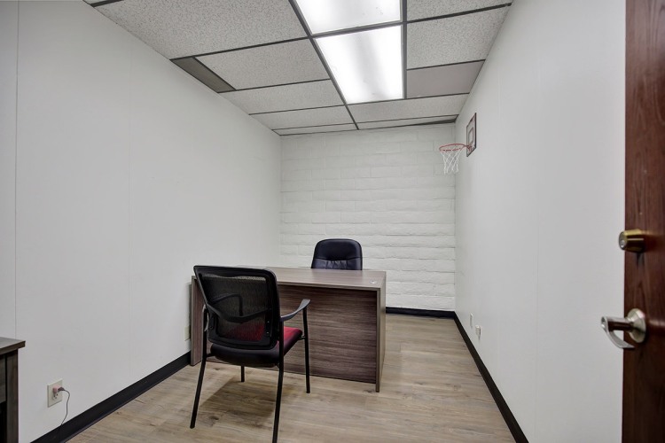 Zoe Behavioral Health's small private office space featuring a desk, chair, and a small basketball court hung on the wall.