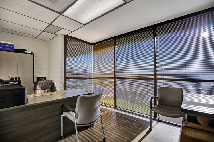 Zoe Behavioral Health's spacious office with a desk and chairs positioned in front of a sizable window.