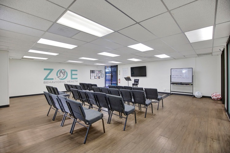 Zoe Behavioral Health's large conference room has a whiteboard and a big logo on the wall.