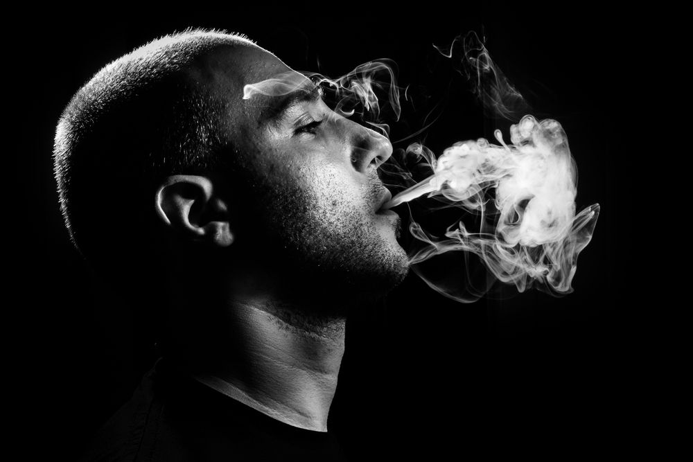 Man puffing out smoke from his mouth