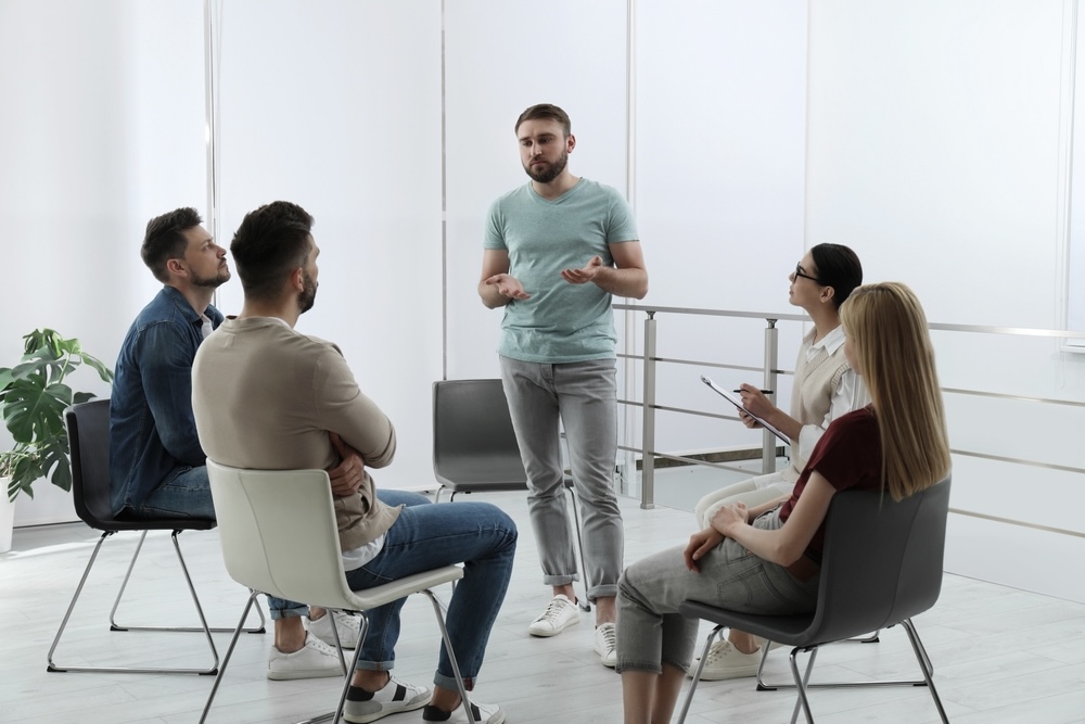 Group of people sharing in a group therapy at drug rehab