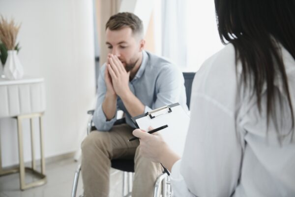 Middle-aged man inside a drug rehab with a therapist