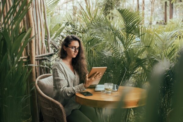 Female in a cafe reading quotes from her smart tablet