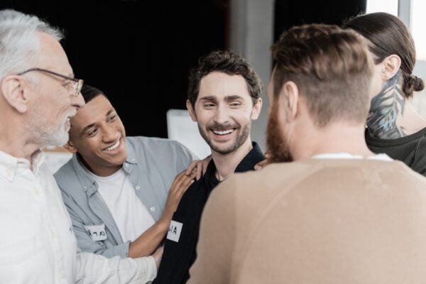 A group of people talking to each other and smiling