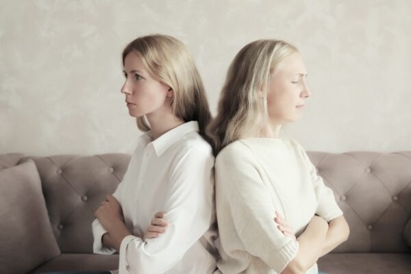 Two women turn their backs at each other while arguing