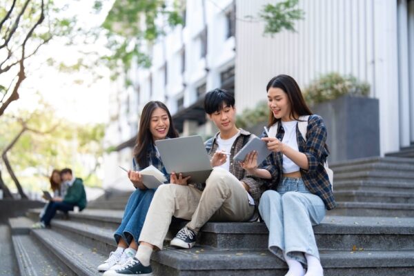 Teens sitting outdoors on the steps with a laptop researching on National Substance Abuse Prevention Month