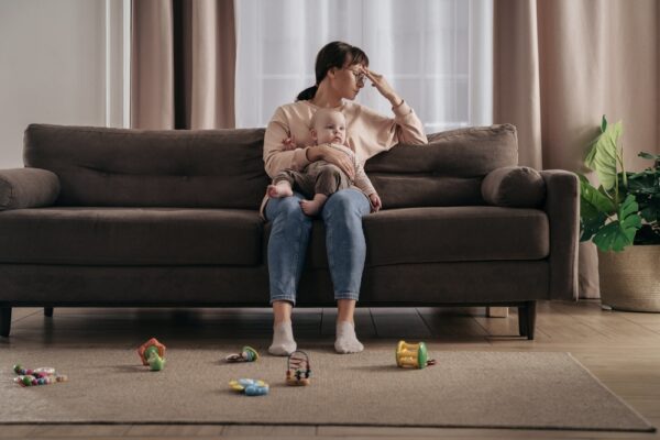 Mom on the couch holding her baby experiencing postpartum depression