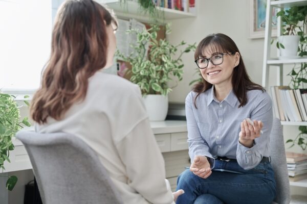 Female dual diagnosis specialist speaking to a young woman patient