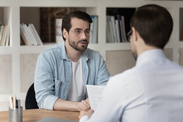 Male patient wearing eyeglasses talking to a therapist