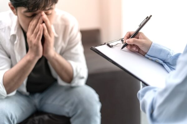 Distressed man talking to a dual diagnosis specialist for treatment