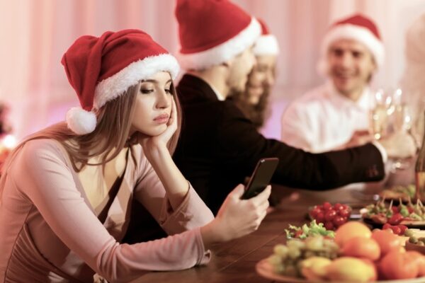 Young female in Santa hat looking upset and anxious during a family gathering