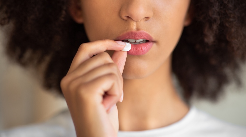 African American woman taking a Vyvanse pill 