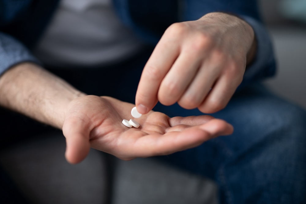 Closeup of a hand counting Vyvanse pills for ADHD