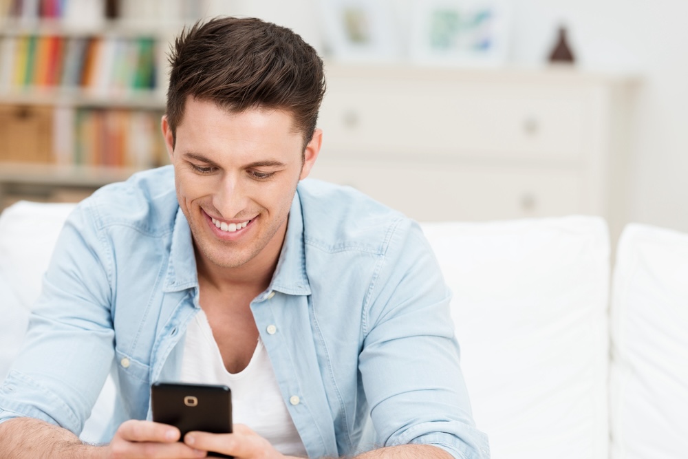 Man in a blue shirt reading sobriety congratulation messages 