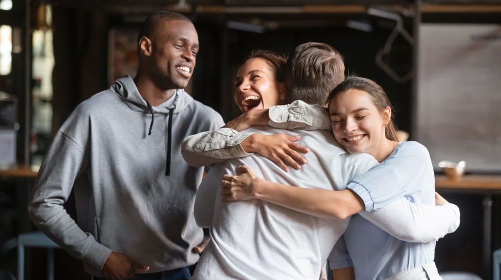 Group of friends hugging each other congratulating on sobriety