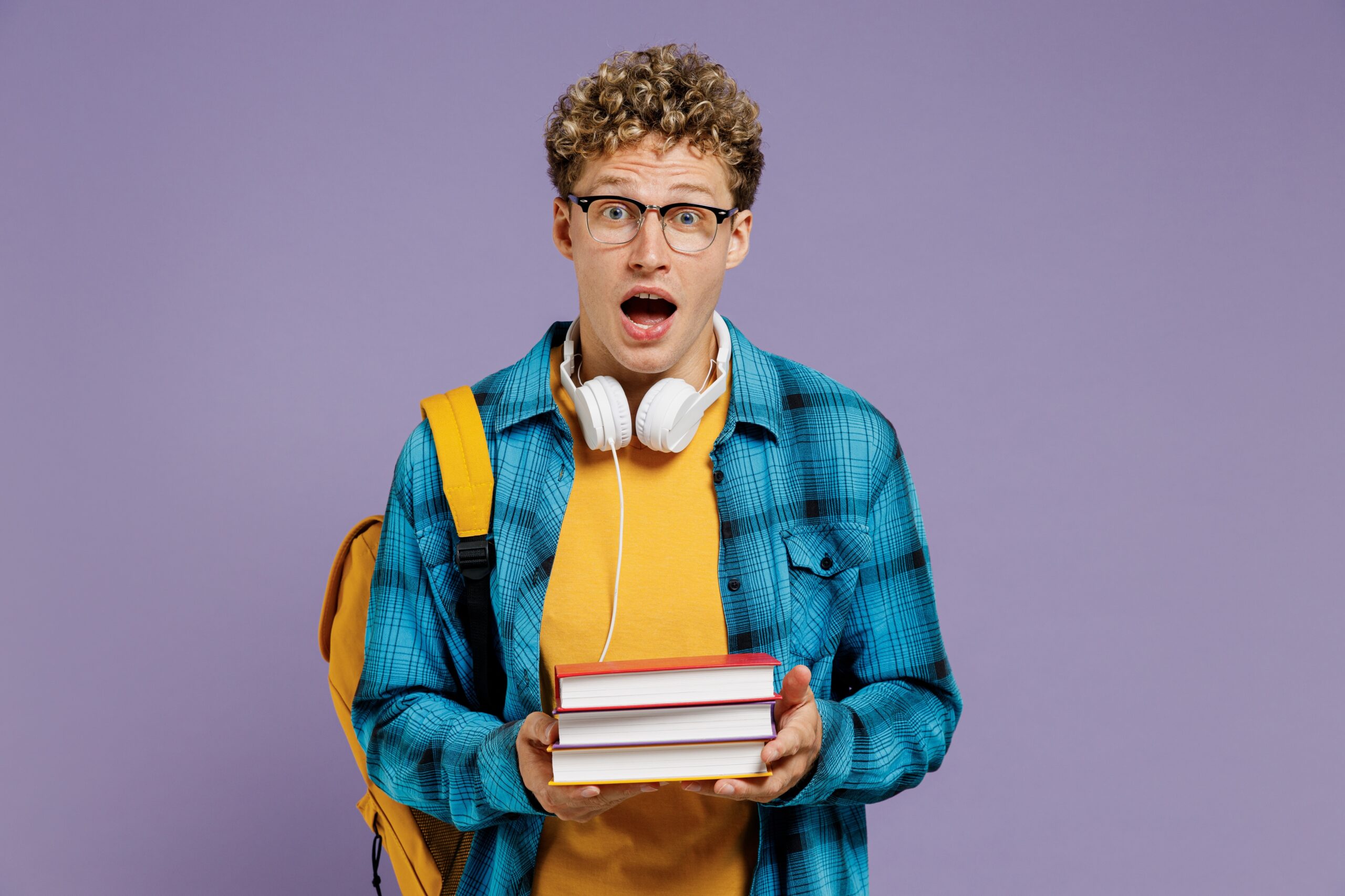 Man holding textbooks wondering why Adderall for studying is dangerous