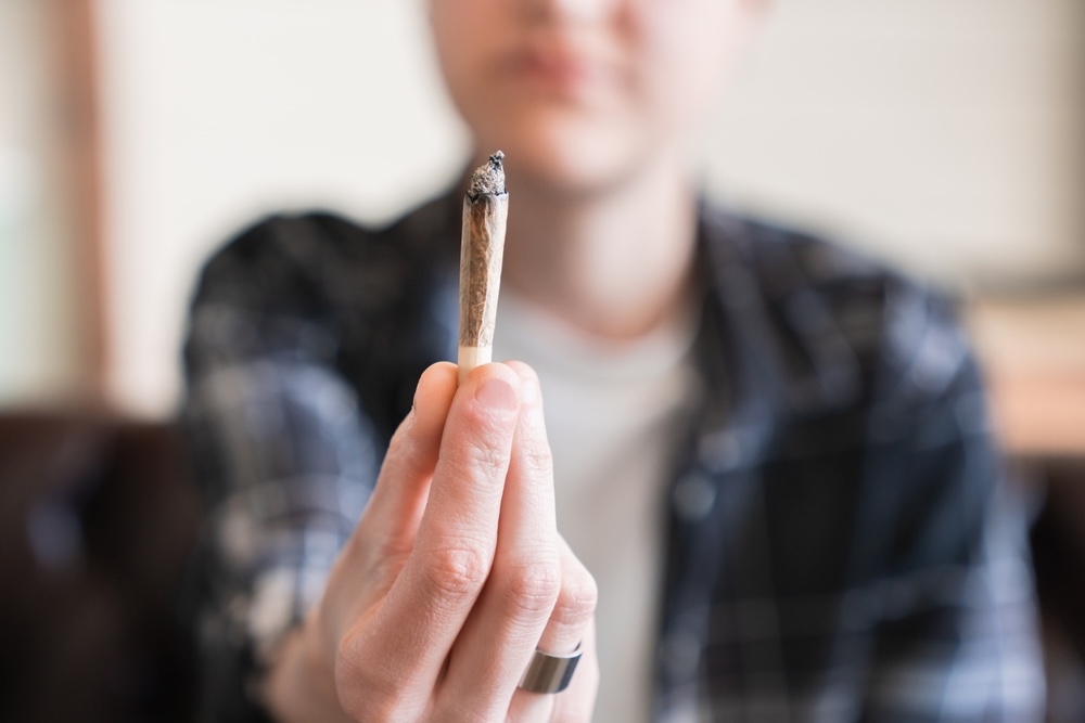 Closeup of a hand holding a weed joint marijuana