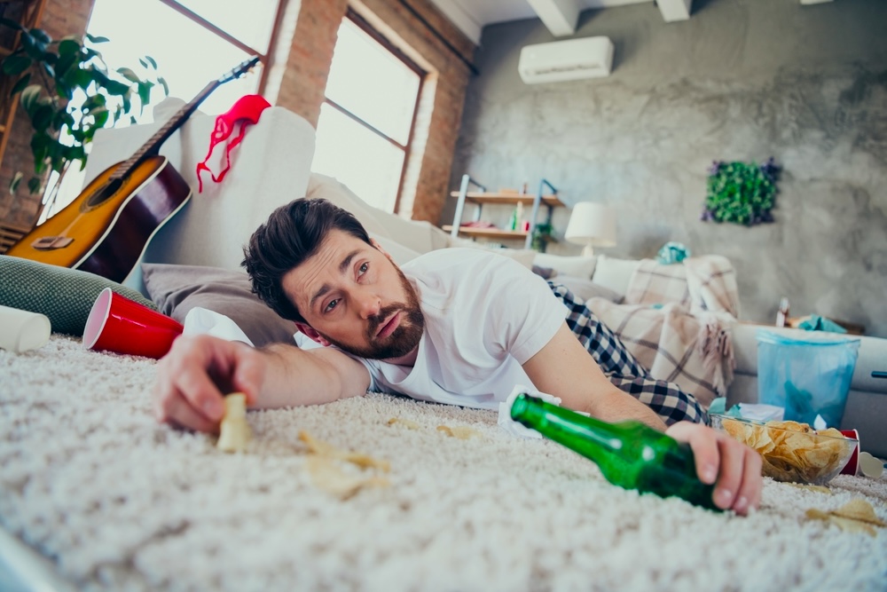 Drunk man on the floor after binge drinking during March Madness