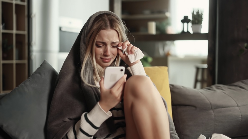 A woman crying after a breakup, experiencing an emotional addiction trigger